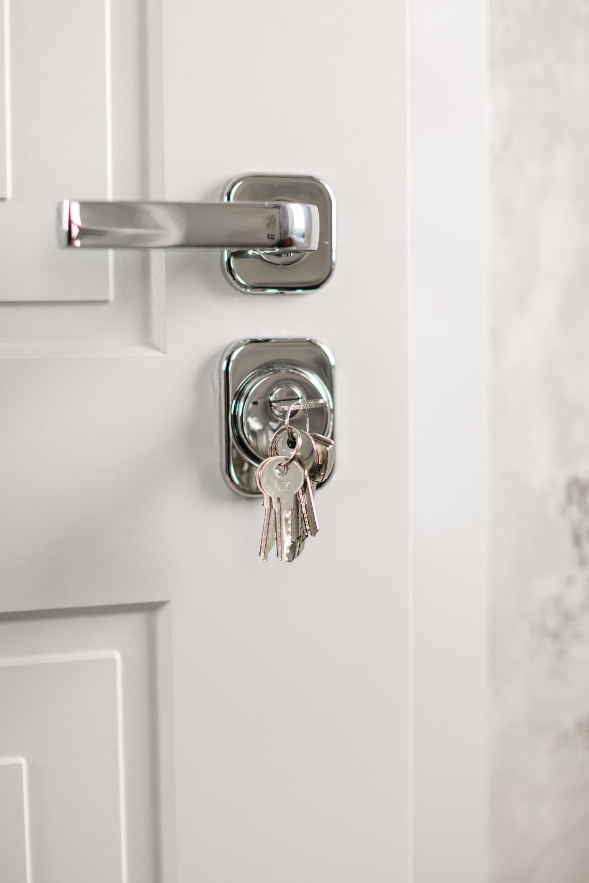 Cylindre de serrure avec trousseau de clés sur une porte blanche